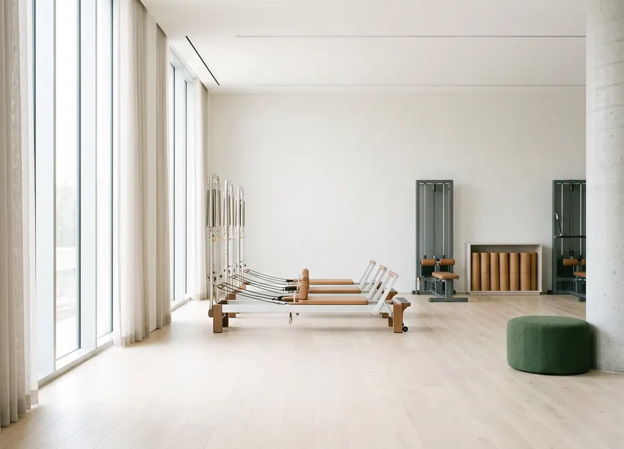 Un studio de bien-être haut de gamme, bois clair et lumière diffuse.